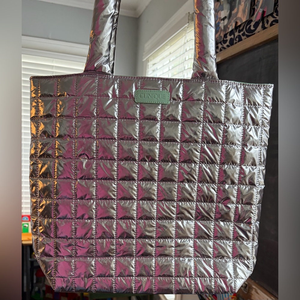 Clinique limited-edition silver quilted tote bag with a pastel green lining.
